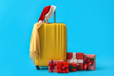 Mavi arka planda Noel Baba şapkalı ve Noel hediyeli çanta.