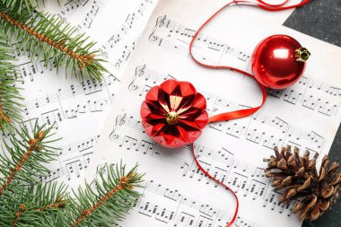 Üzerinde Noel topları, kurdele ve köknar dalları olan not kağıtları.