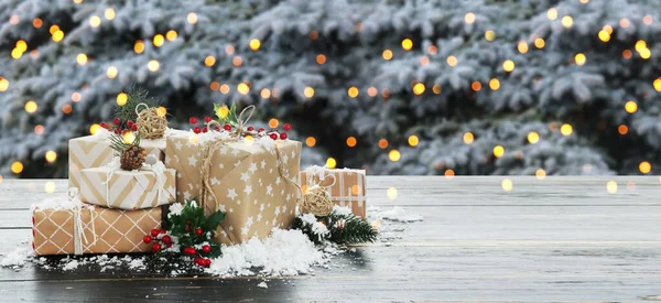 テーブルの上の美しいクリスマスのギフトボックス 雪と装飾 — ストック写真