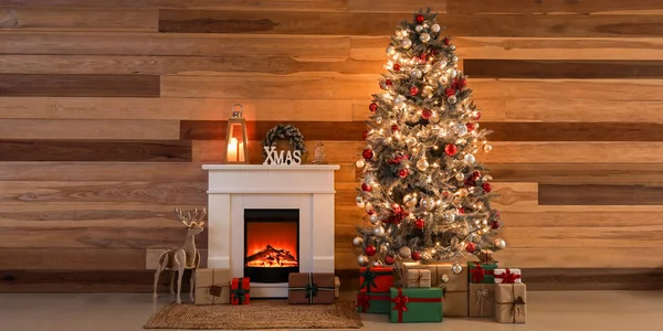 漂亮的圣诞树 房间里木墙旁边有礼品 壁炉和装饰品 — 图库照片
