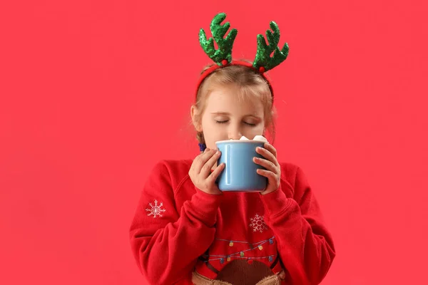 Happy Little Girl Reindeer Horns Drinking Cocoa Red Background — Stock Photo, Image