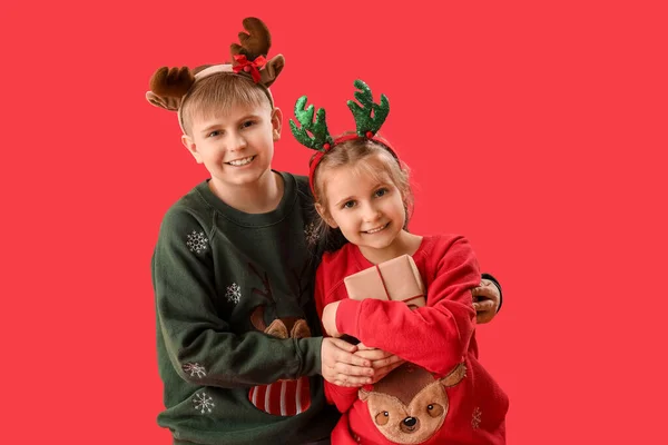 Glückliche Kleine Kinder Rentierhörnern Mit Weihnachtsgeschenken Auf Rotem Hintergrund — Stockfoto