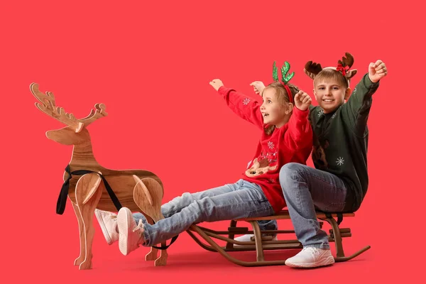 Glückliche Kleine Kinder Mit Schlitten Und Holz Rentieren Auf Rotem — Stockfoto