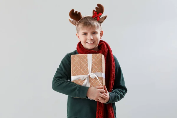 Szczęśliwy Chłopczyk Rogach Reniferów Prezentem Świątecznym Lekkim Tle — Zdjęcie stockowe
