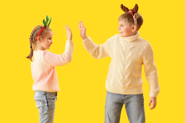 Szczęśliwe Małe Dzieci Rogach Reniferów Dając Sobie Przybij Piątkę Żółtym — Zdjęcie stockowe