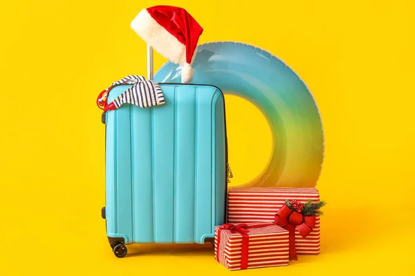 Koffer Mit Weihnachtsmütze Weihnachtsgeschenken Und Reiseaccessoires Auf Gelbem Hintergrund — Stockfoto