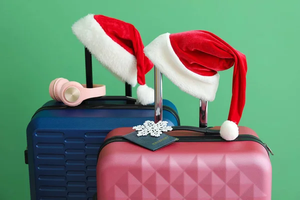 Koffer Mit Nikolausmützen Schneeflocke Reisepass Und Kopfhörer Auf Grünem Hintergrund — Stockfoto