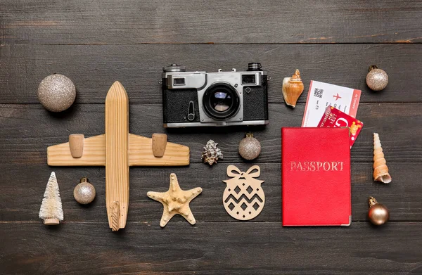 暗い木製の背景にパスポート 写真カメラ おもちゃの飛行機 貝殻やクリスマスの装飾 — ストック写真