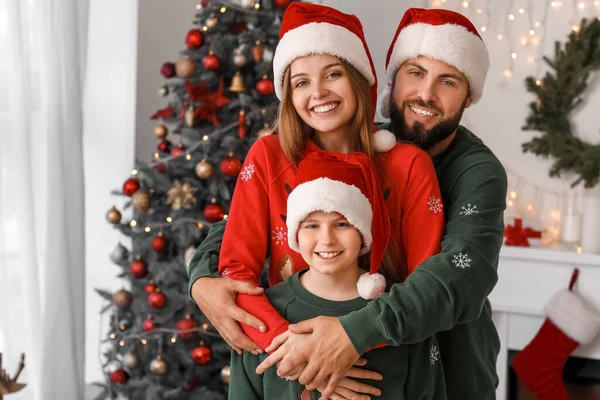 Щасливі Батьки Своїм Маленьким Сином Капелюхах Обіймаються Вдома Напередодні Різдва — стокове фото