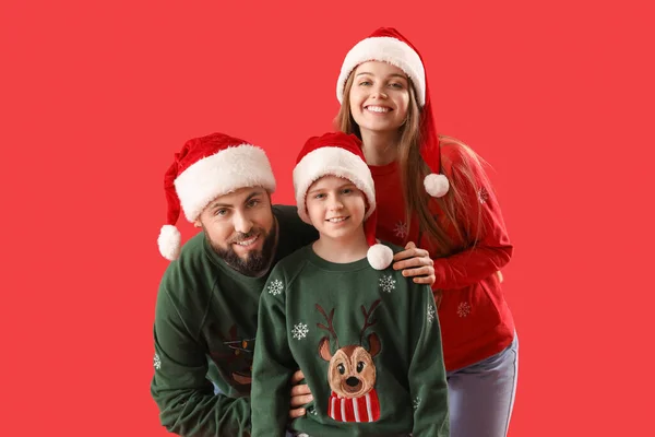 Mutlu Ebeveynler Kırmızı Arka Planda Noel Baba Şapkalı Küçük Oğulları — Stok fotoğraf