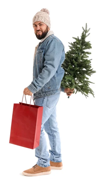 白い背景にクリスマスツリーとショッピングバッグを持つハンサムな男 — ストック写真