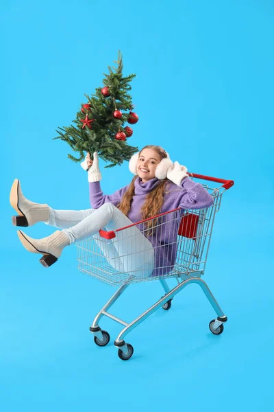 Junge Frau Mit Weihnachtsbaum Einkaufswagen Auf Blauem Hintergrund — Stockfoto