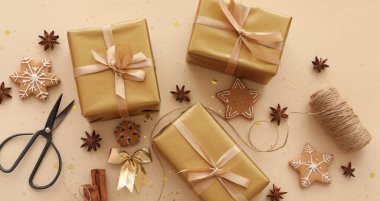 Bej arka planda el yapımı güzel Noel hediyeleri ve kurabiyeler olan kompozisyon