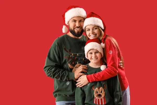 Glückliche Eltern Mit Ihrem Kleinen Sohn Nikolausmützen Auf Rotem Hintergrund — Stockfoto