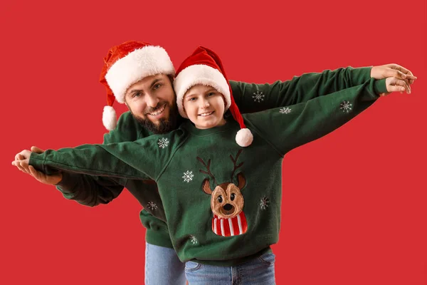 Pai Feliz Com Seu Filho Chapéus Papai Noel Fundo Vermelho — Fotografia de Stock