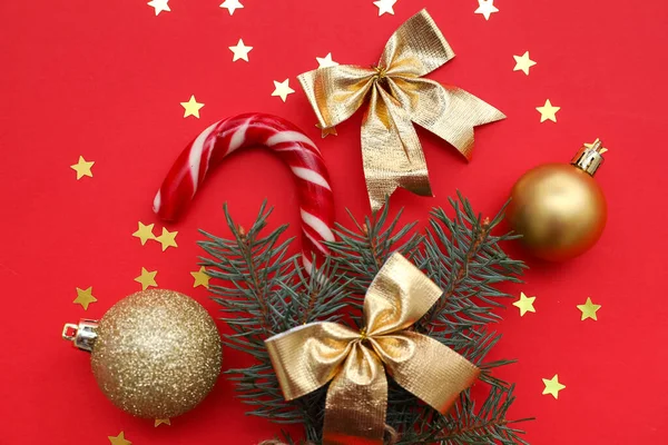 モミの枝と構成 クリスマスの装飾 赤い背景にお菓子の杖とコンフェッティ クローズアップ — ストック写真