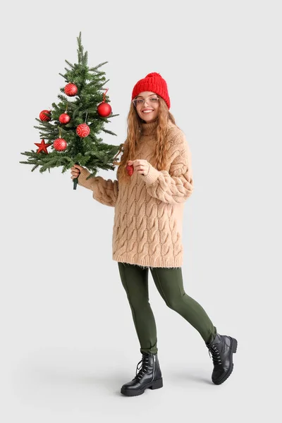 Gri Arka Planda Noel Ağacı Dekoru Olan Genç Bir Kadın — Stok fotoğraf