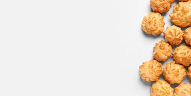 Beyaz arkaplanda birçok lezzetli profiterol, metin ve üst görünüm için yer var.