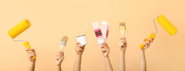 Bej arka planda ressam aletleri olan kadın elleri