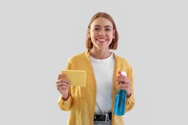 Deterjan şişesi ve süngeri olan güzel bir kadın.