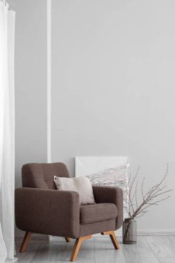 Odadaki ışık duvarının yanında şık bir koltuk ve yastık.