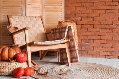 Modern odanın içinde Rattan koltuğu ve balkabağı