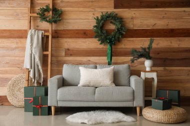 Noel çelengi ve hediyelerle modern oturma odasının şık bir iç mekanı.