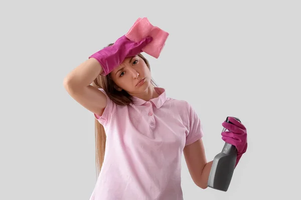 Giovane Donna Stanca Con Bottiglia Spray Detergente Straccio Sfondo Chiaro — Foto Stock