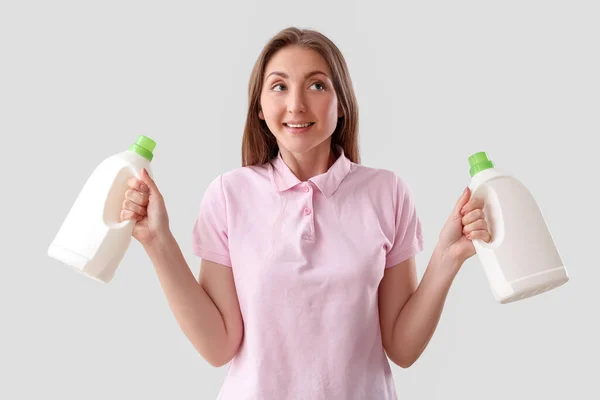 Mujer Joven Con Botellas Detergente Sobre Fondo Claro —  Fotos de Stock