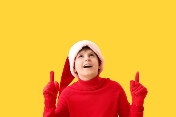 Little Boy Santa Hat Pointing Something Yellow Background — Stock Photo, Image