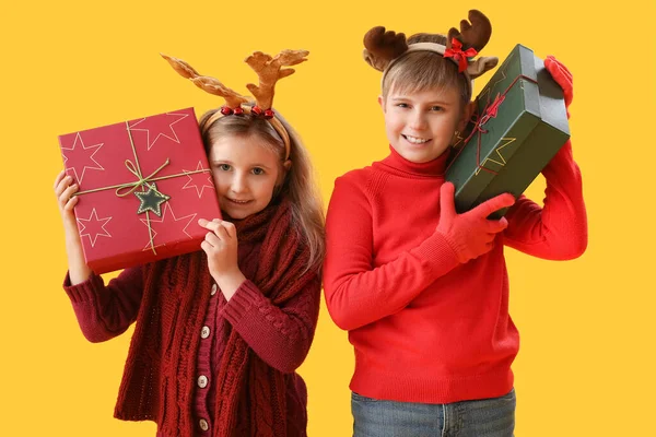 Kleine Kinder Rentierhörnern Mit Weihnachtsgeschenken Auf Gelbem Hintergrund — Stockfoto
