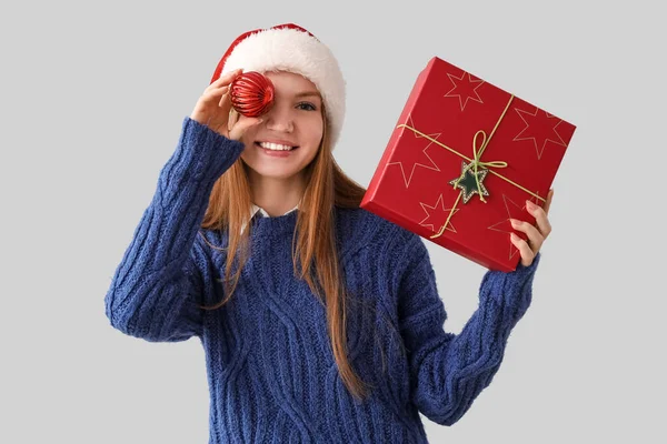 Jonge Vrouw Santa Hoed Met Kerstbal Aanwezig Grijze Achtergrond — Stockfoto