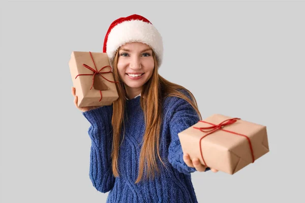 Jonge Vrouw Santa Hoed Met Kerstcadeaus Grijze Achtergrond — Stockfoto