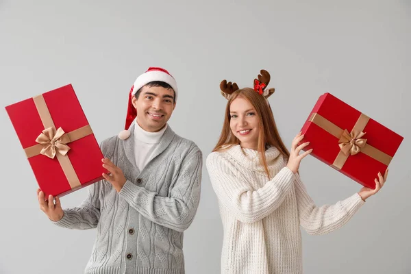 Lykkelig Ungt Par Med Julegaver Grå Bakgrunn – stockfoto