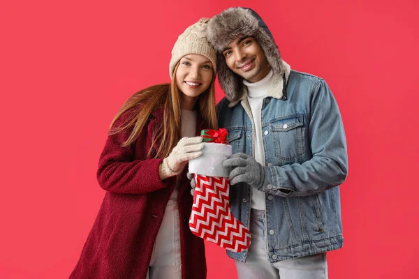 Joyeux Jeune Couple Avec Chaussette Noël Cadeau Sur Fond Rouge — Photo