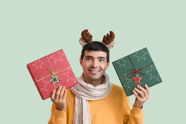 Happy Young Man Reindeer Horns Christmas Gifts Green Background — Stock Photo, Image