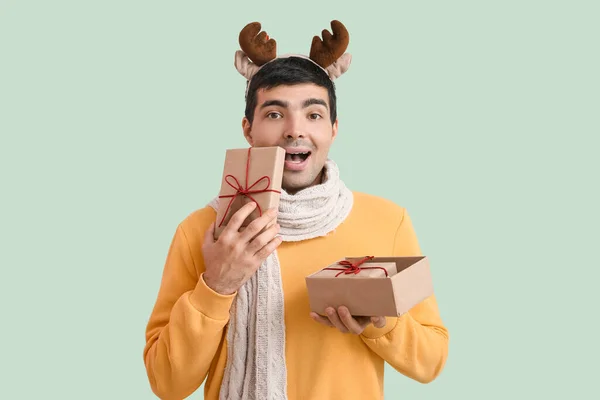 Happy Young Man Reindeer Horns Christmas Gifts Green Background — Stock Photo, Image