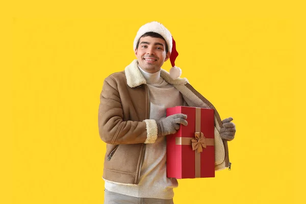 Mladý Muž Santa Klobouk Vánoční Dárek Žlutém Pozadí — Stock fotografie