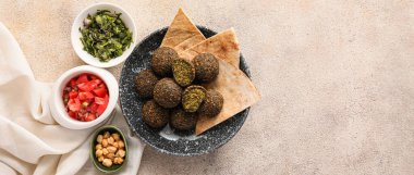 Lezzetli falafel köfteli tabaklar, hafif arka planda bulunan pitalar ve malzemeler ve metin için yer.