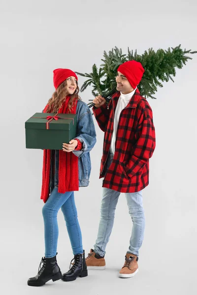 Junges Verliebtes Paar Mit Weihnachtsbaum Und Geschenk Auf Grauem Hintergrund — Stockfoto