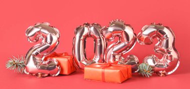 2023 model balonlardan ve kırmızı arka planda Noel hediyelerinden yapılmış.