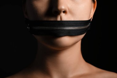 Young woman with zipper on her mouth against dark background, closeup. Censorship concept clipart