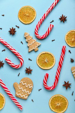 Lezzetli şeker kamışları, kurabiyeler, baharatlar ve arkaplanda kurutulmuş portakal dilimleri olan kompozisyon