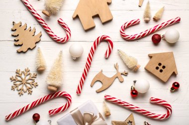 Şeker kamışlı kompozisyon ve beyaz ahşap arka planda farklı bir Noel dekoru.