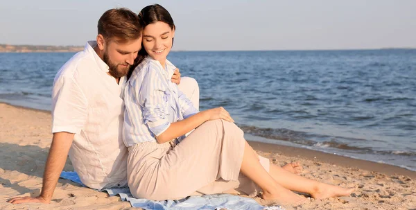 幸せな若いカップルが海のビーチに座っている — ストック写真