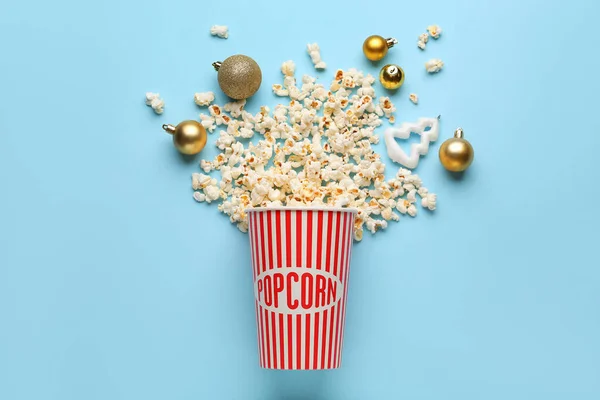 stock image Bucket of popcorn and Christmas balls on blue background