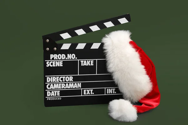 stock image Movie clapper with Santa hat on green background