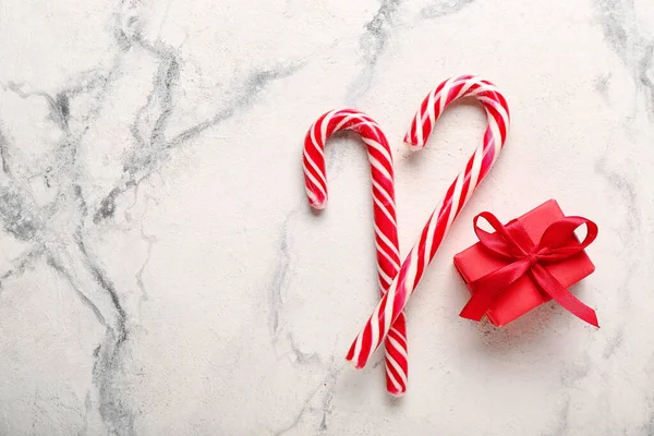 Süße Zuckerstangen Und Weihnachtsgeschenk Auf Hellem Hintergrund — Stockfoto
