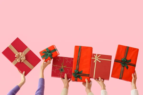 stock image People with Christmas gift boxes on pink background