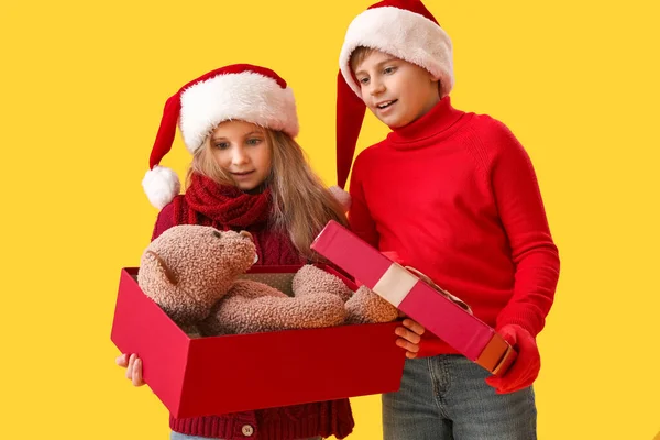 Kleine Kinder Nikolausmützen Mit Geöffneter Weihnachtsgeschenkbox Auf Gelbem Hintergrund — Stockfoto